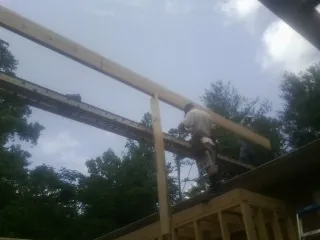 Carpenter setting a ridge beam over a new addition frame — Ice Dam Removal by Roofing Brothers in Hopewell