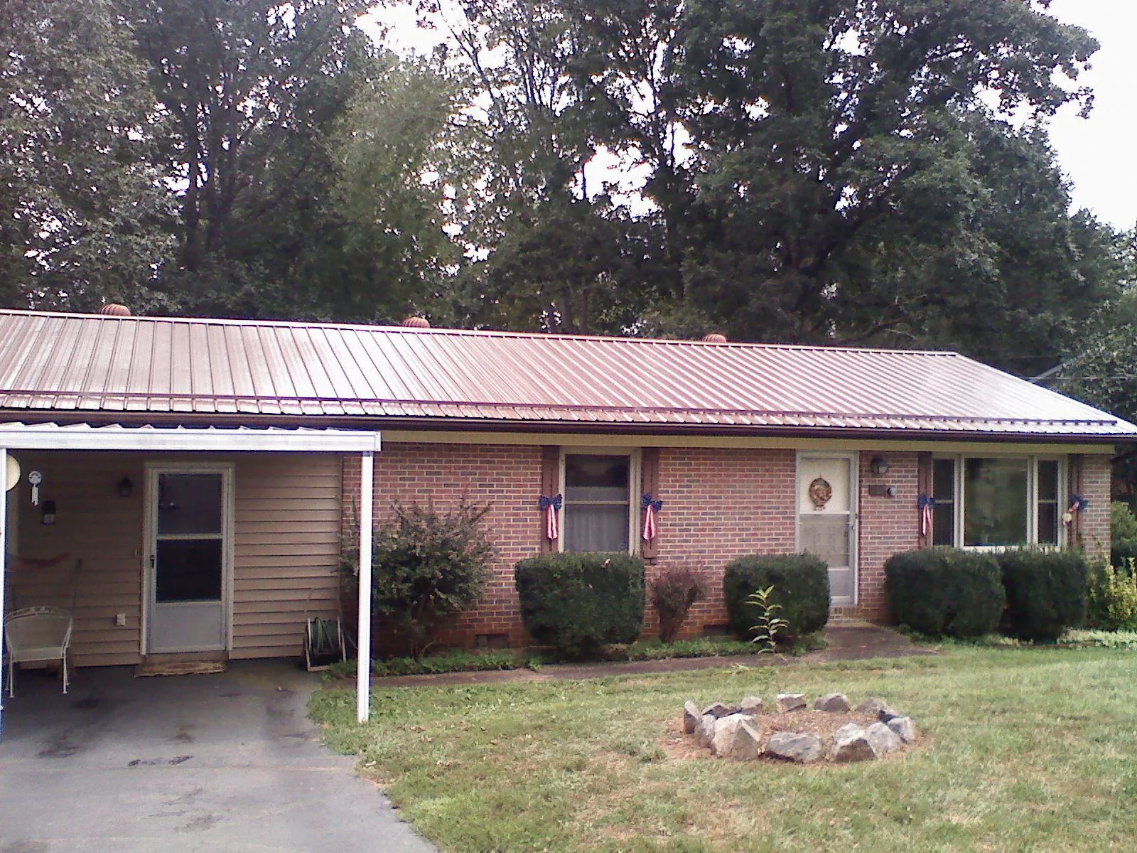 Bronze metal roof and carport on a brick ranch home — Roof Repair work by our crew in Hopewell